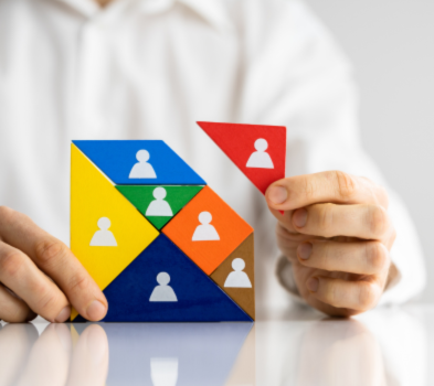 Client Presentation Hands hold a colorful tangram puzzle with person icons, adding a red triangle—a visual metaphor for building a team.